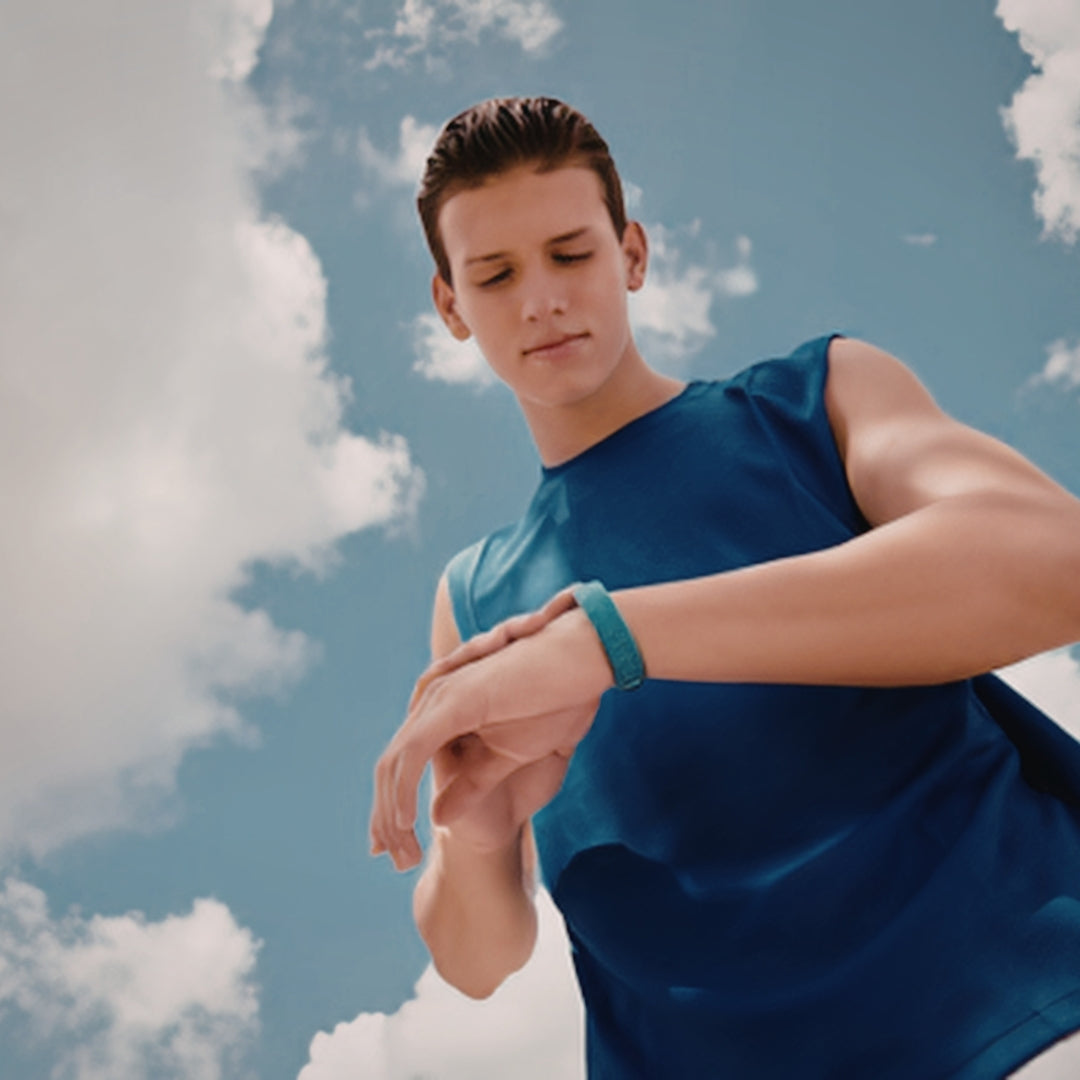 Person wearing a blue sleeveless shirt against a cloudy sky